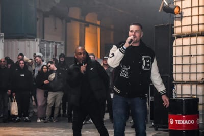 Twee mc's met microfoon op het podium in de hal