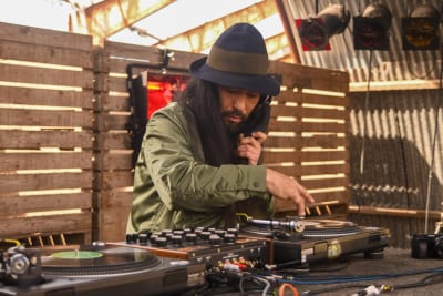 Een dj met hoed achter de draaitafels